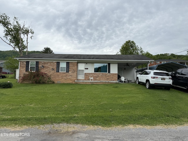 ranch-style home with a carport, brick siding, and a front lawn