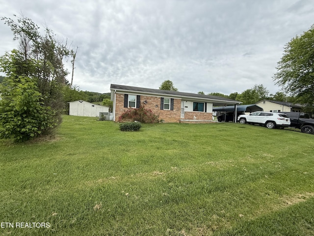 view of front of property featuring brick siding, a front yard, and an attached carport