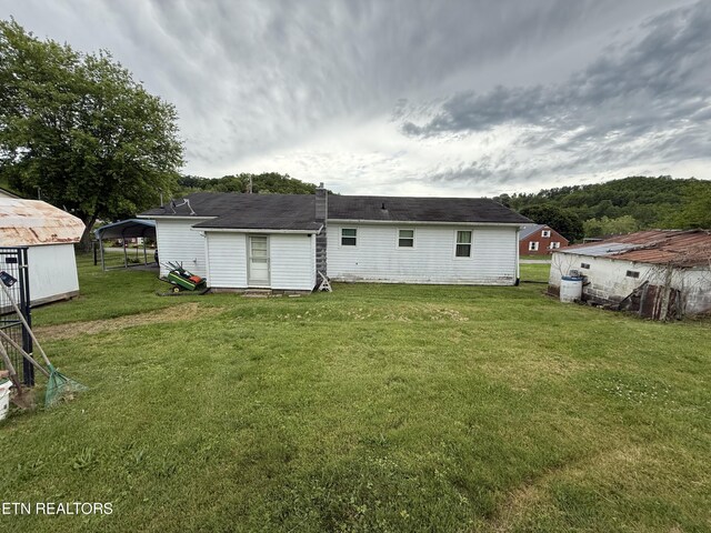 back of property featuring a yard