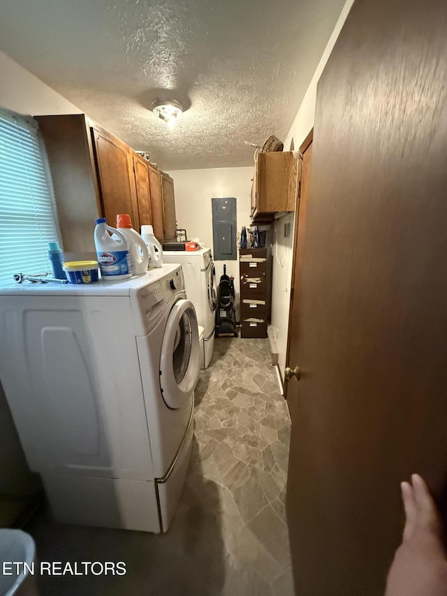 laundry area with cabinet space, separate washer and dryer, electric panel, and a textured ceiling