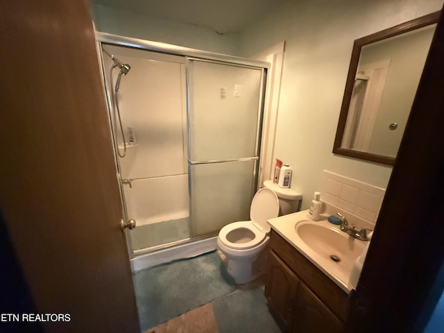 full bathroom featuring a stall shower, vanity, and toilet