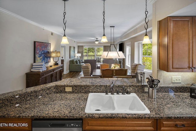 kitchen with a sink, brown cabinets, ornamental molding, and dishwasher