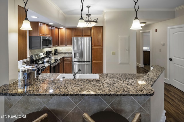 kitchen with stainless steel appliances, a sink, dark wood-style floors, crown molding, and brown cabinetry