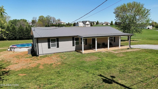 1712 Old Oak Grove Rd, Dandridge, TN 37725 - back of property featuring an outdoor pool, a lawn, metal roof, and covered porch