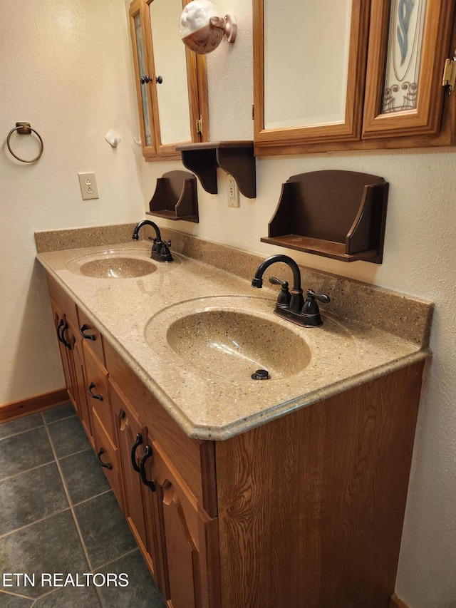 full bath featuring tile patterned floors, double vanity, and baseboards