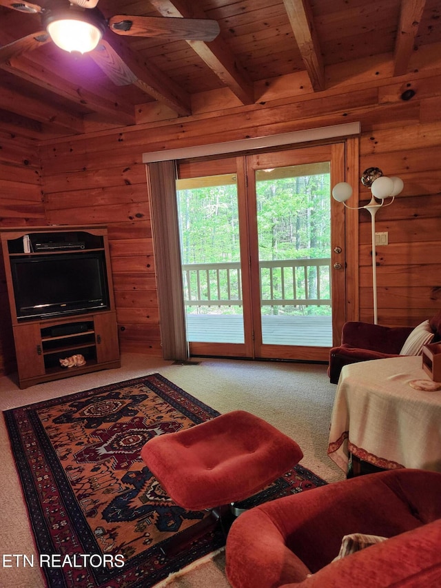 carpeted living area featuring beam ceiling, wooden walls, and wood ceiling