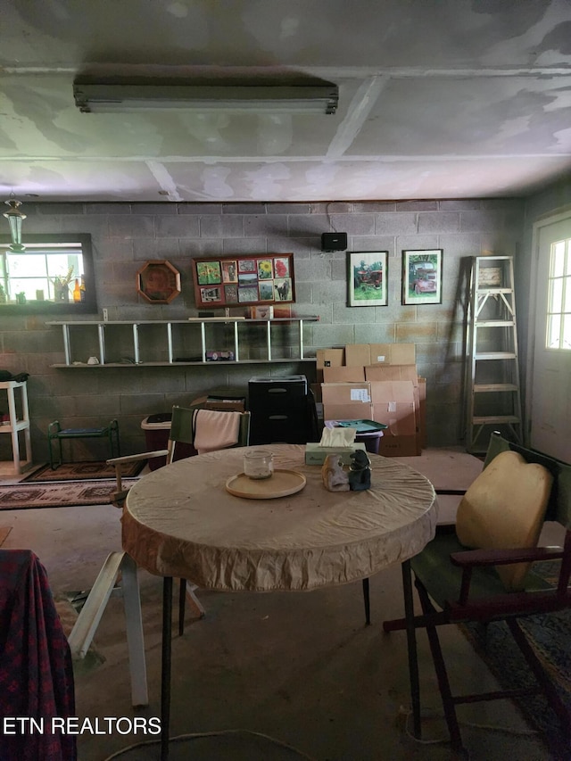 dining room featuring concrete block wall and healthy amount of natural light