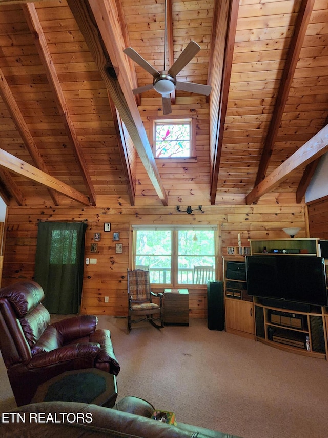 carpeted living area with wooden ceiling, wood walls, and a ceiling fan