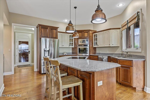 200 Bluffton Rd, Friendsville, TN 37737 - kitchen with appliances with stainless steel finishes, a sink, a kitchen island, glass insert cabinets, and light stone counters