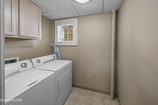 washroom featuring cabinet space, washing machine and dryer, baseboards, and light tile patterned floors