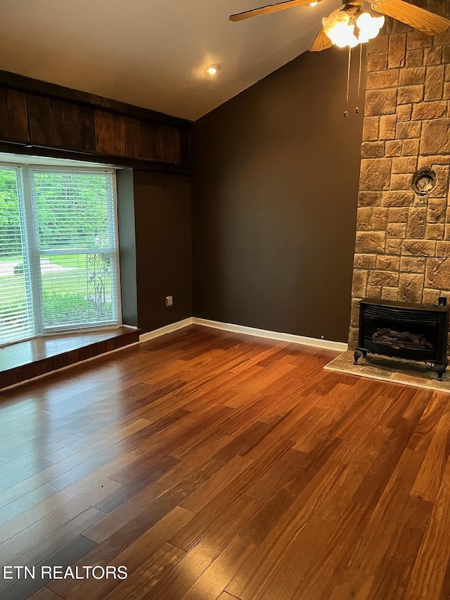 180 Cedar Ln, Jacksboro, TN 37757 - unfurnished living room with a stone fireplace, a ceiling fan, vaulted ceiling, and wood finished floors