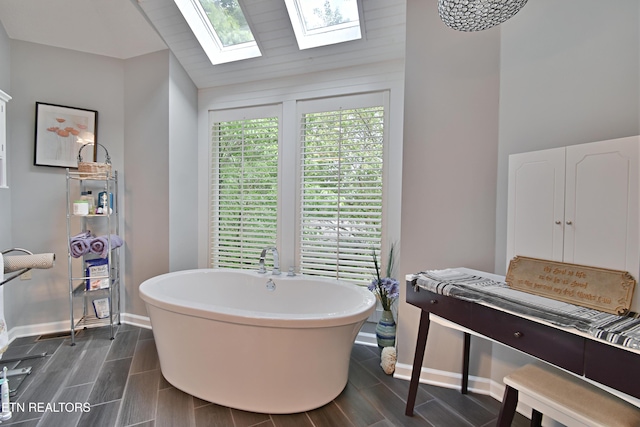 12212 Oakmont Cir, Knoxville, TN 37934 - full bathroom featuring a skylight, a freestanding bath, wood finish floors, baseboards, and vaulted ceiling