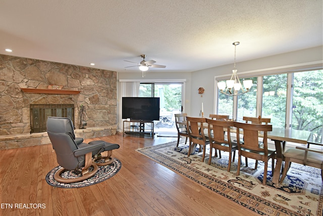 12212 Oakmont Cir, Knoxville, TN 37934 - dining area with wood finished floors, a textured ceiling, ceiling fan, a chandelier, and a fireplace