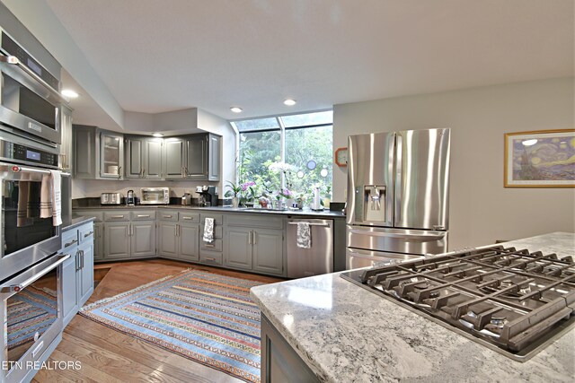 12212 Oakmont Cir, Knoxville, TN 37934 - kitchen featuring stainless steel appliances, gray cabinets, light wood-type flooring, recessed lighting, and light stone countertops