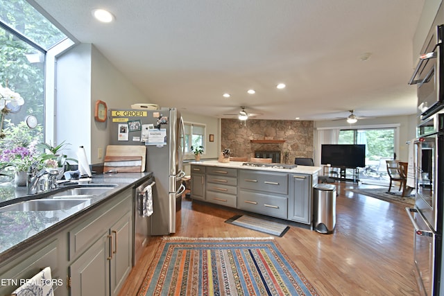 12212 Oakmont Cir, Knoxville, TN 37934 - kitchen with gray cabinetry, a stone fireplace, a sink, open floor plan, and a ceiling fan