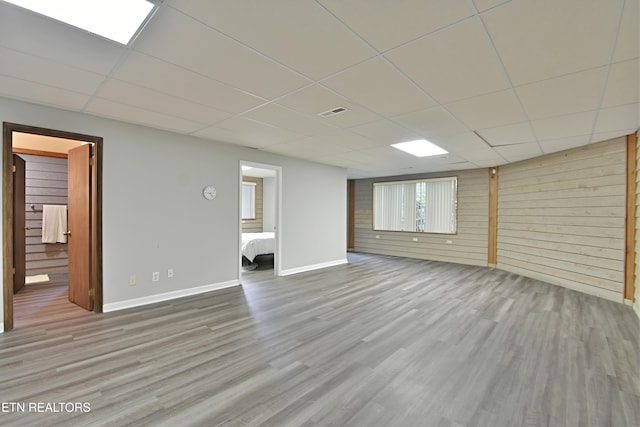 12212 Oakmont Cir, Knoxville, TN 37934 - unfurnished living room featuring a drop ceiling, wood finished floors, wood walls, and baseboards