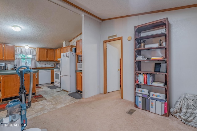 384 Lancer Rd, Harriman, TN 37748 - kitchen with white appliances, a textured ceiling, ornamental molding, brown cabinetry, and light colored carpet