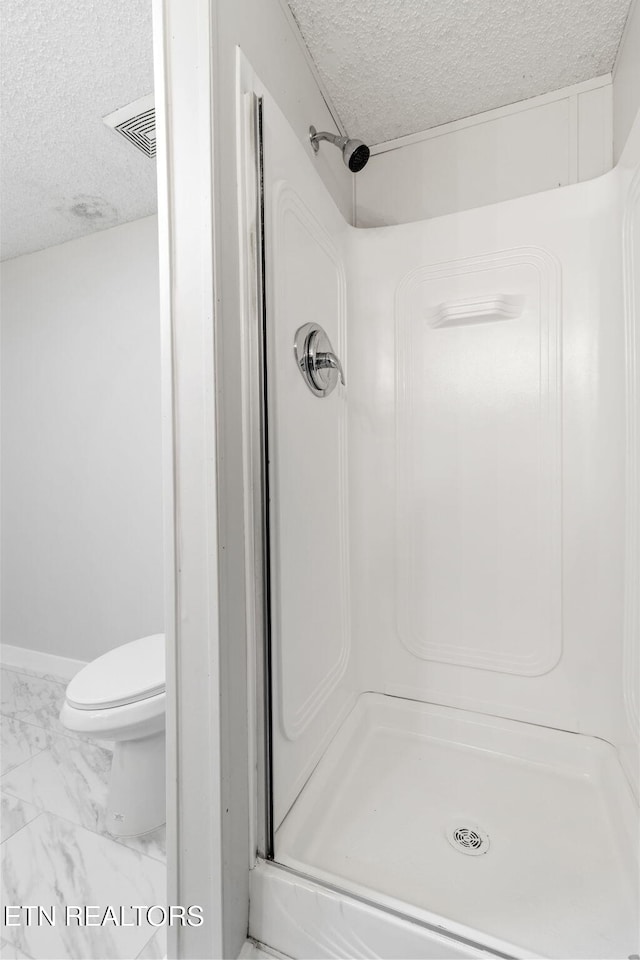 4817 Howardsville Rd, Apison, TN 37302 - full bathroom with a textured ceiling, marble finish floors, a stall shower, and toilet