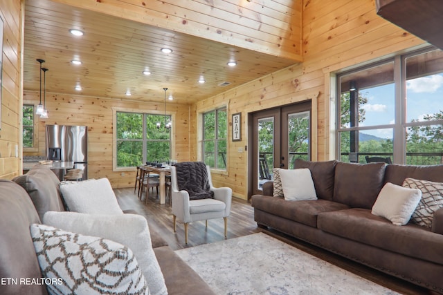 living room with recessed lighting, wooden walls, french doors, wooden ceiling, and healthy amount of natural light