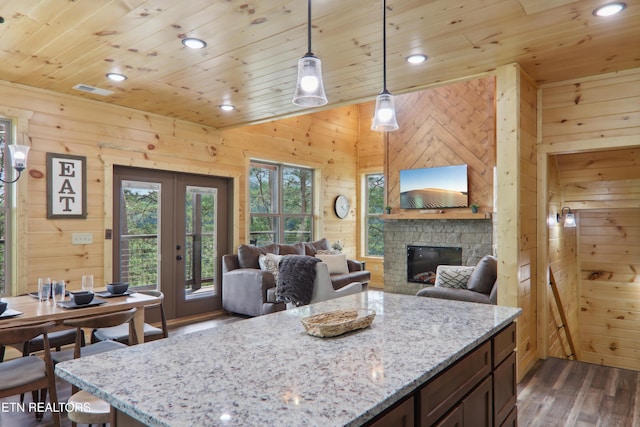 kitchen featuring wood ceiling, dark wood-type flooring, wood walls, a fireplace, and french doors