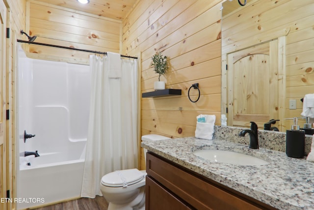 full bath featuring wood walls, toilet, vanity, wood finished floors, and shower / tub combo with curtain