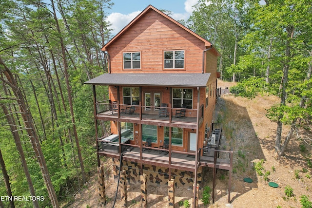 rear view of house with a wooden deck, french doors, and stairs