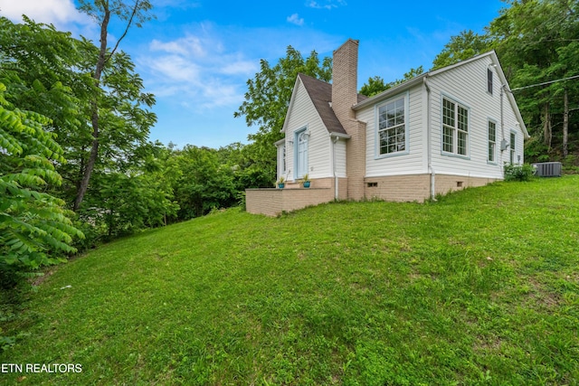 739 W Main St, Sevierville, TN 37862 - view of side of home with central AC unit, a lawn, a chimney, and crawl space