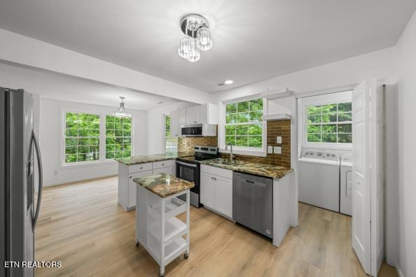 739 W Main St, Sevierville, TN 37862 - kitchen with appliances with stainless steel finishes, washing machine and dryer, a peninsula, and plenty of natural light
