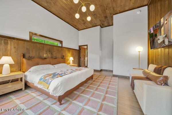 bedroom with wood ceiling, wood walls, lofted ceiling, and a chandelier