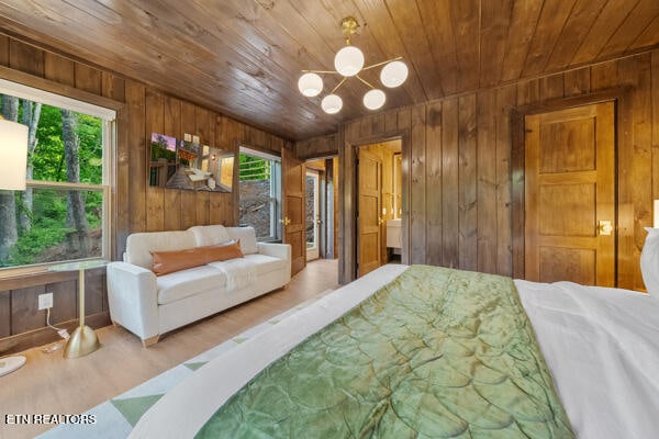 bedroom featuring wooden ceiling, wood walls, a chandelier, and wood finished floors