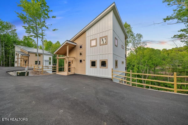view of front facade featuring board and batten siding and fence