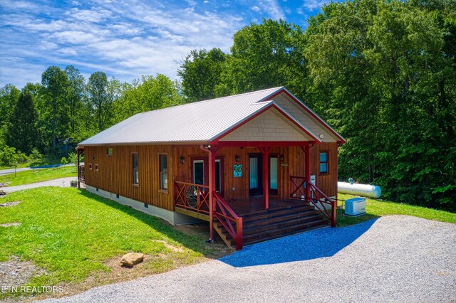 305 Griffin Ln, Allardt, TN 38504 - chalet / cabin with covered porch, a front lawn, metal roof, and view of wooded area
