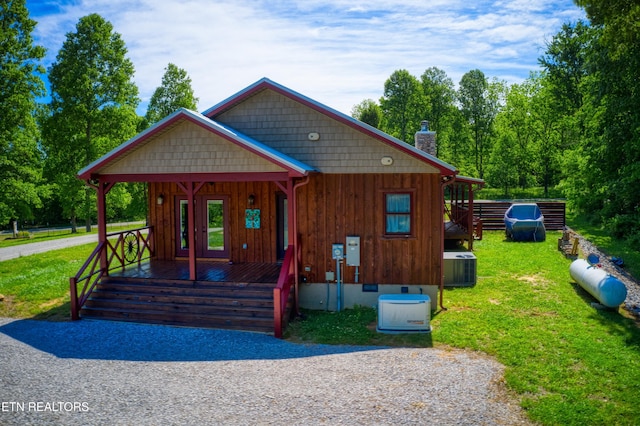 305 Griffin Ln, Allardt, TN 38504 - rustic home with a chimney, a porch, a front yard, and cooling unit