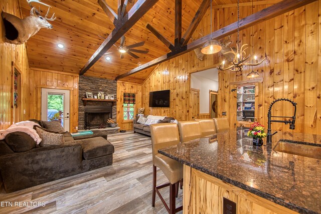 305 Griffin Ln, Allardt, TN 38504 - living room with high vaulted ceiling, wood walls, wood finished floors, wooden ceiling with exposed beams, and a chandelier