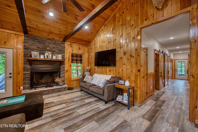 305 Griffin Ln, Allardt, TN 38504 - living room with wood-type flooring, wood walls, plenty of natural light, a stone fireplace, and ceiling fan