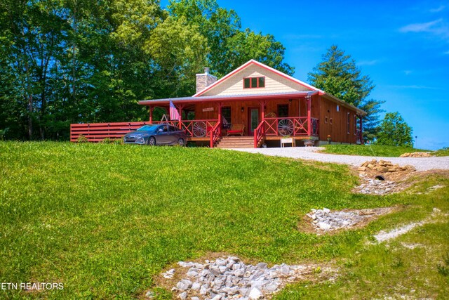 305 Griffin Ln, Allardt, TN 38504 - view of front facade with covered porch, a chimney, a front yard, and board and batten siding