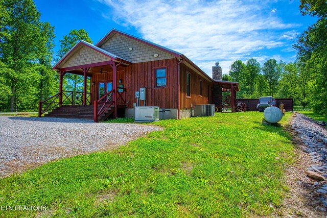 305 Griffin Ln, Allardt, TN 38504 - view of front of house with a chimney, central AC, a front yard, board and batten siding, and ceiling fan