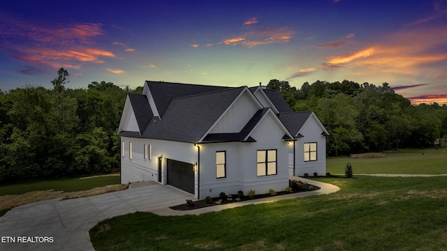 modern inspired farmhouse with driveway, a yard, a garage, and roof with shingles