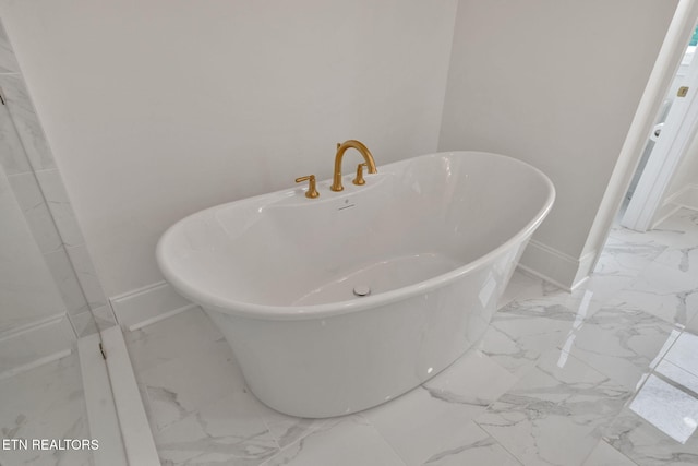 bathroom view of baseboards and a soaking tub