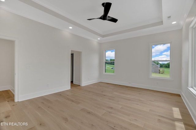 unfurnished room featuring a tray ceiling, light wood-type flooring, ceiling fan, recessed lighting, and baseboards