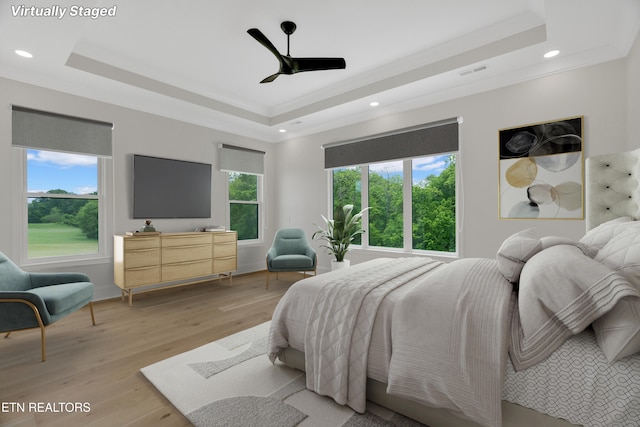 bedroom featuring a raised ceiling, recessed lighting, light wood-style floors, ceiling fan, and ornamental molding
