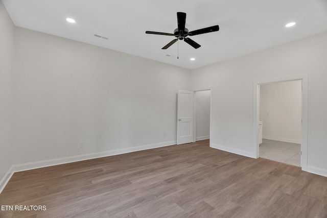 unfurnished bedroom featuring wood finished floors, baseboards, recessed lighting, a ceiling fan, and ensuite bath