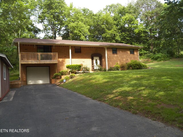 1634 Snodderly Dr, Lenoir City, TN 37771 - view of front of property featuring asphalt driveway, a front yard, an attached garage, and a balcony