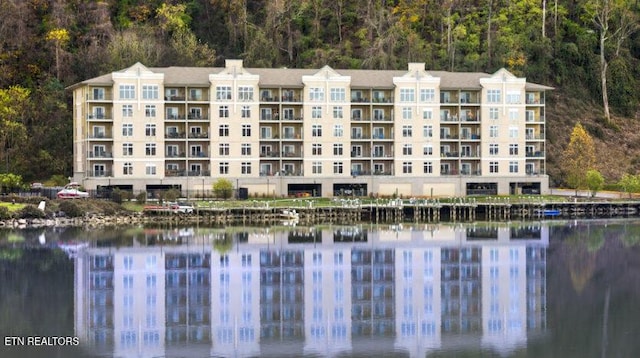 view of building exterior featuring a water view and a wooded view