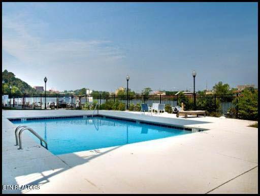 community pool with fence and a patio