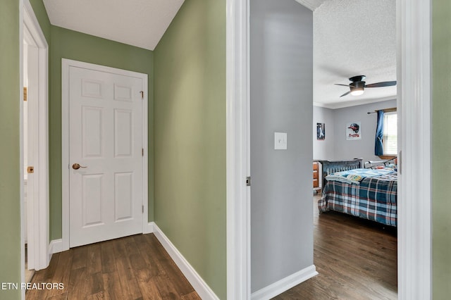 1023 NE Old Charleston Rd, Cleveland, TN 37312 - corridor with dark wood-style flooring, a textured ceiling, and baseboards
