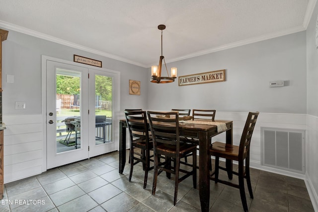 1023 NE Old Charleston Rd, Cleveland, TN 37312 - dining space featuring ornamental molding, a chandelier, dark tile patterned flooring, wainscoting, and a textured ceiling