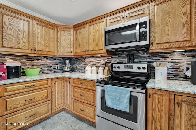 1023 NE Old Charleston Rd, Cleveland, TN 37312 - kitchen with stainless steel appliances, backsplash, light tile patterned flooring, and light stone counters