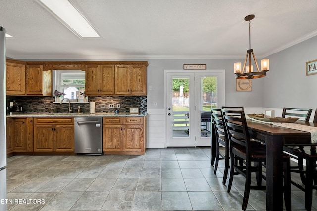 1023 NE Old Charleston Rd, Cleveland, TN 37312 - kitchen with stainless steel dishwasher, brown cabinetry, decorative backsplash, and crown molding