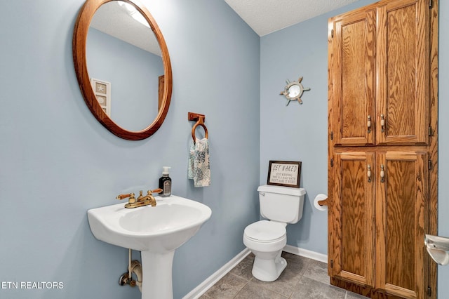 1023 NE Old Charleston Rd, Cleveland, TN 37312 - half bath featuring toilet, baseboards, a textured ceiling, and tile patterned floors